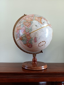 A decorative globe sits on a wooden table.