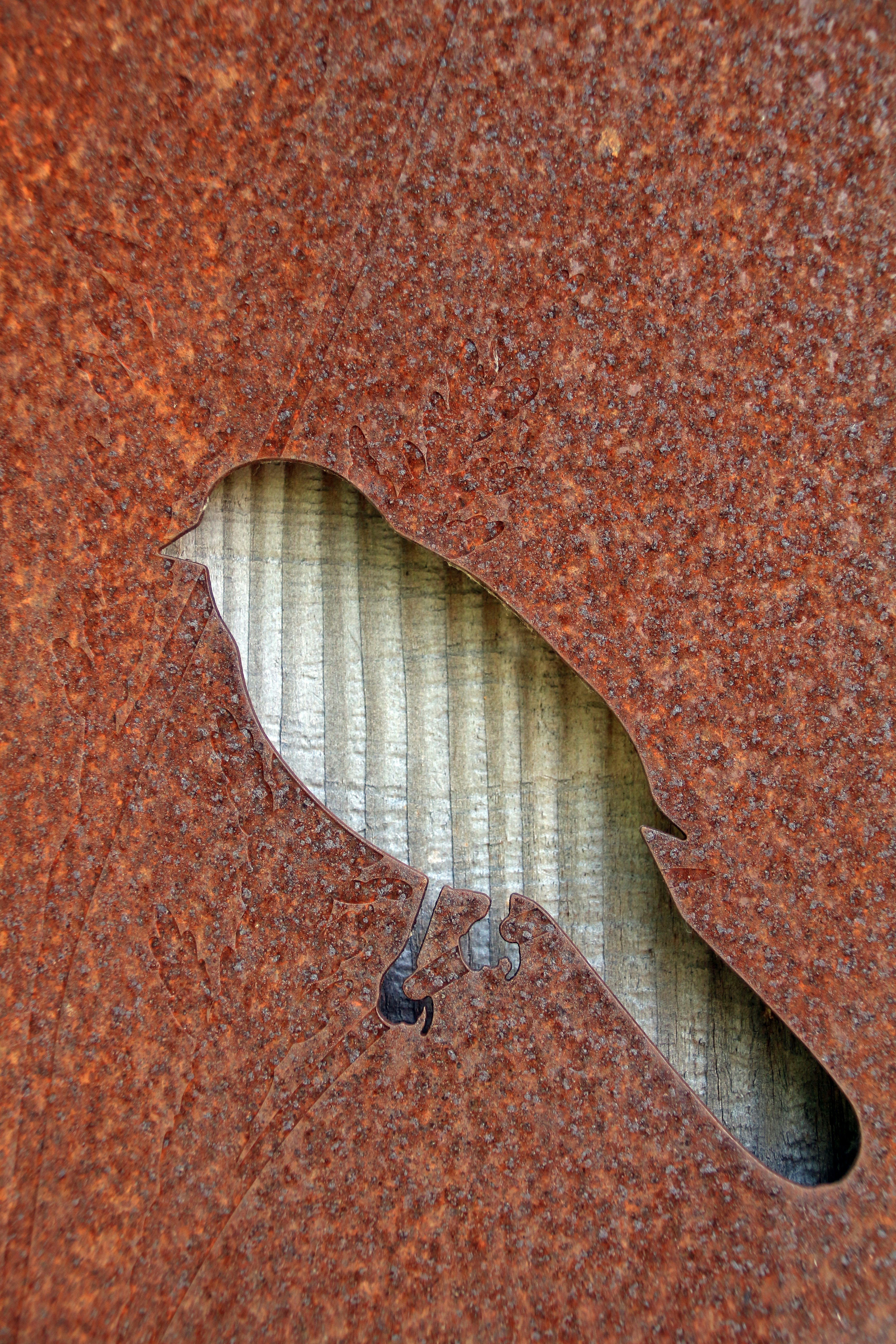 Vogelsilhouette in verrostetes Metall geschnitten.