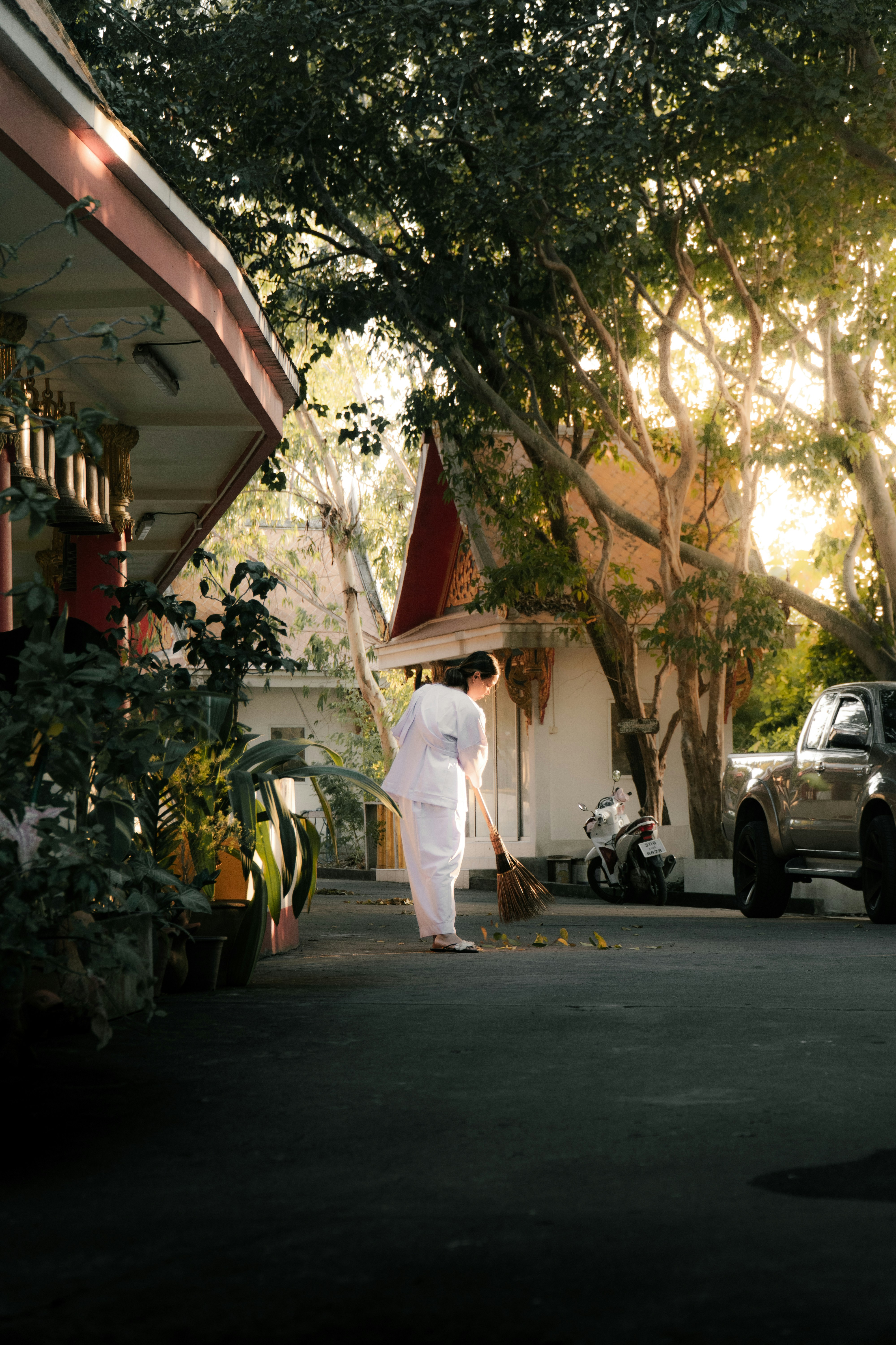 お寺で紅葉を掃く人。