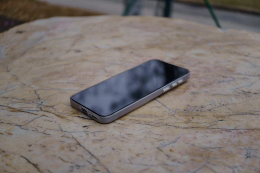 A smartphone rests on a textured surface.