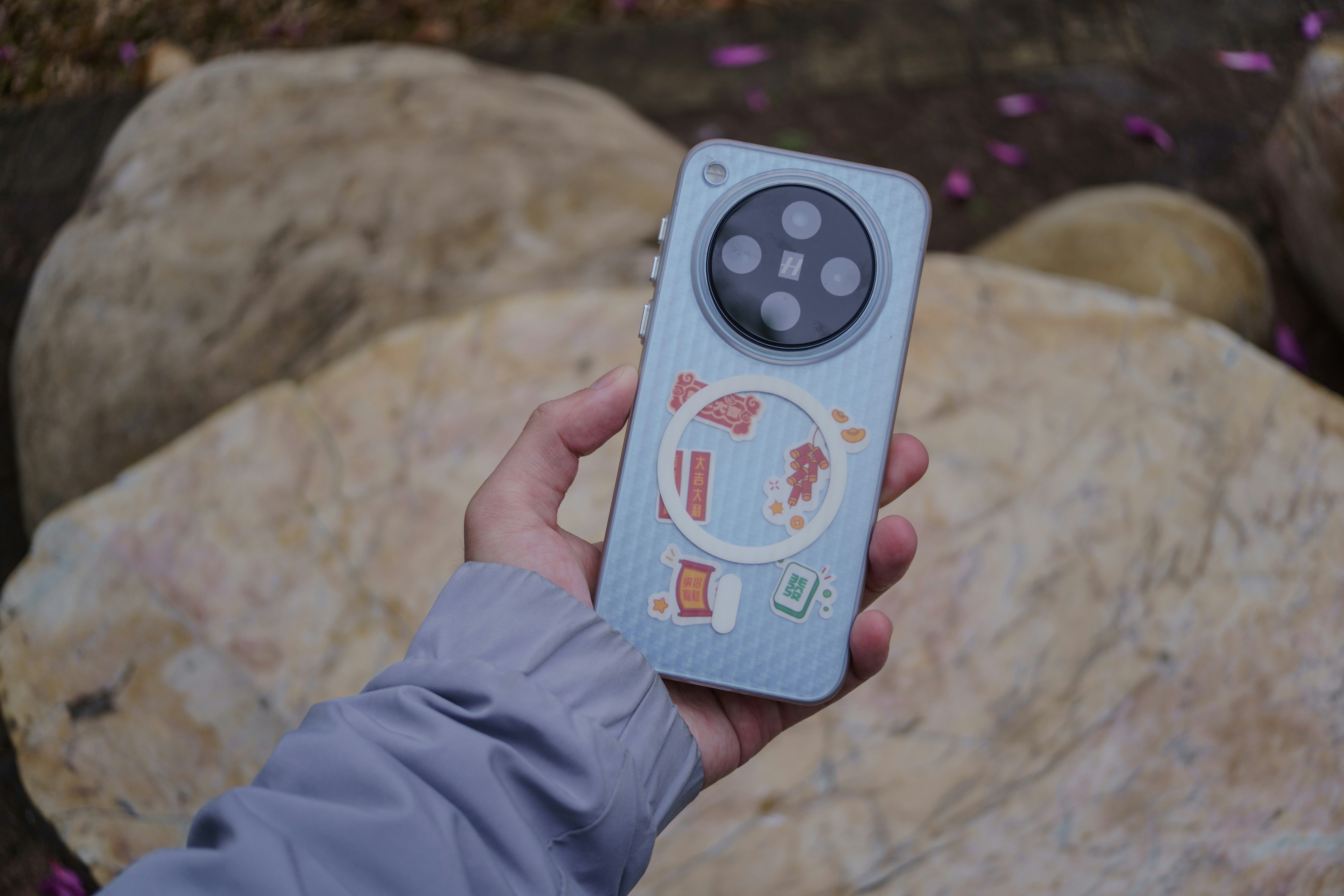 A hand holds a phone with a unique design.