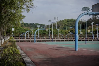Empty basketball court with curved hoops and lights.