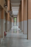 An empty, tiled corridor stretches toward the light.