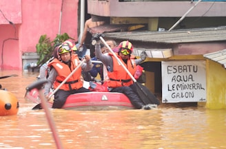Rescue workers navigate floodwaters in a boat.