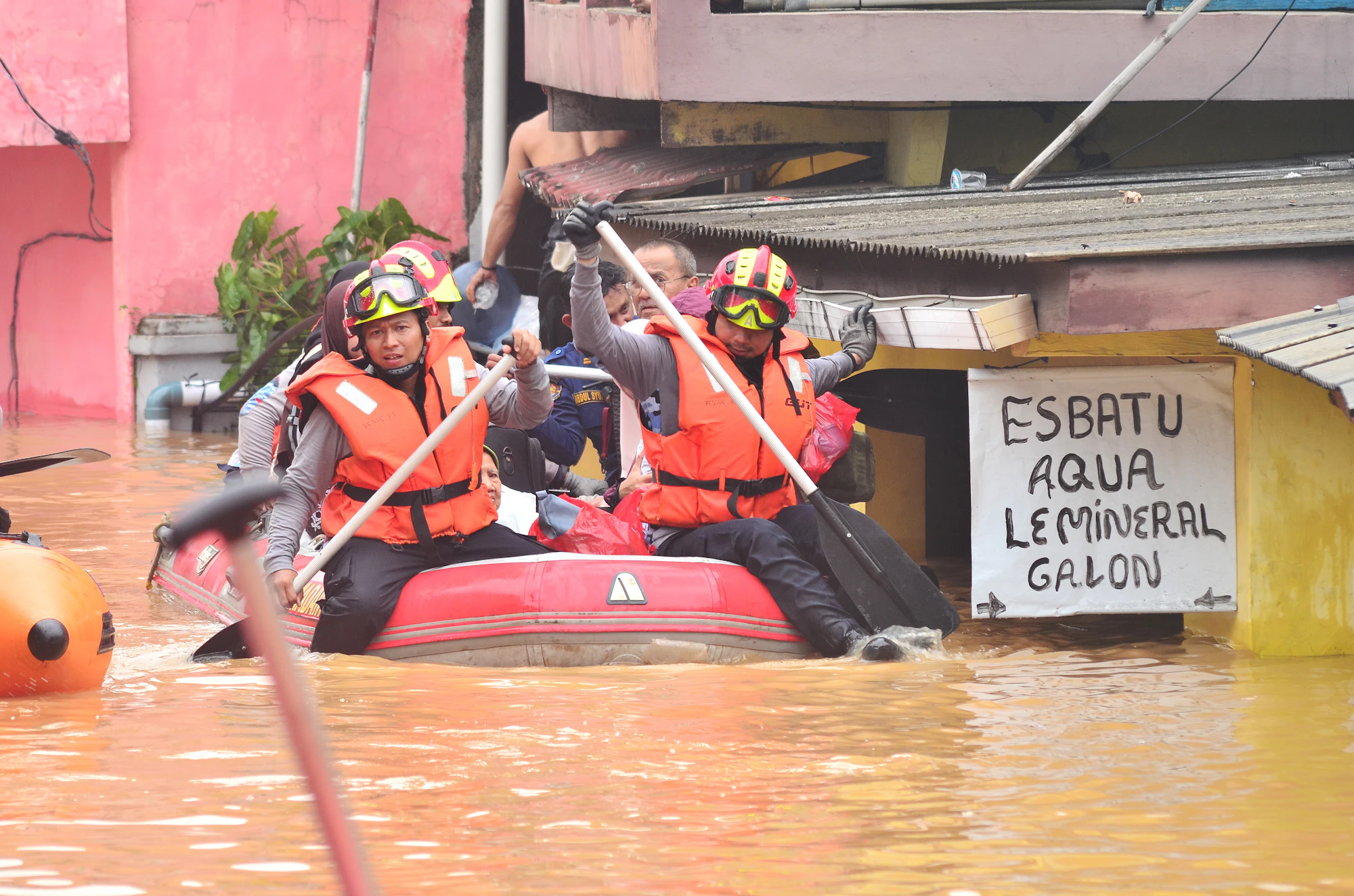 Equipe de resgate navegando por uma área alagada
