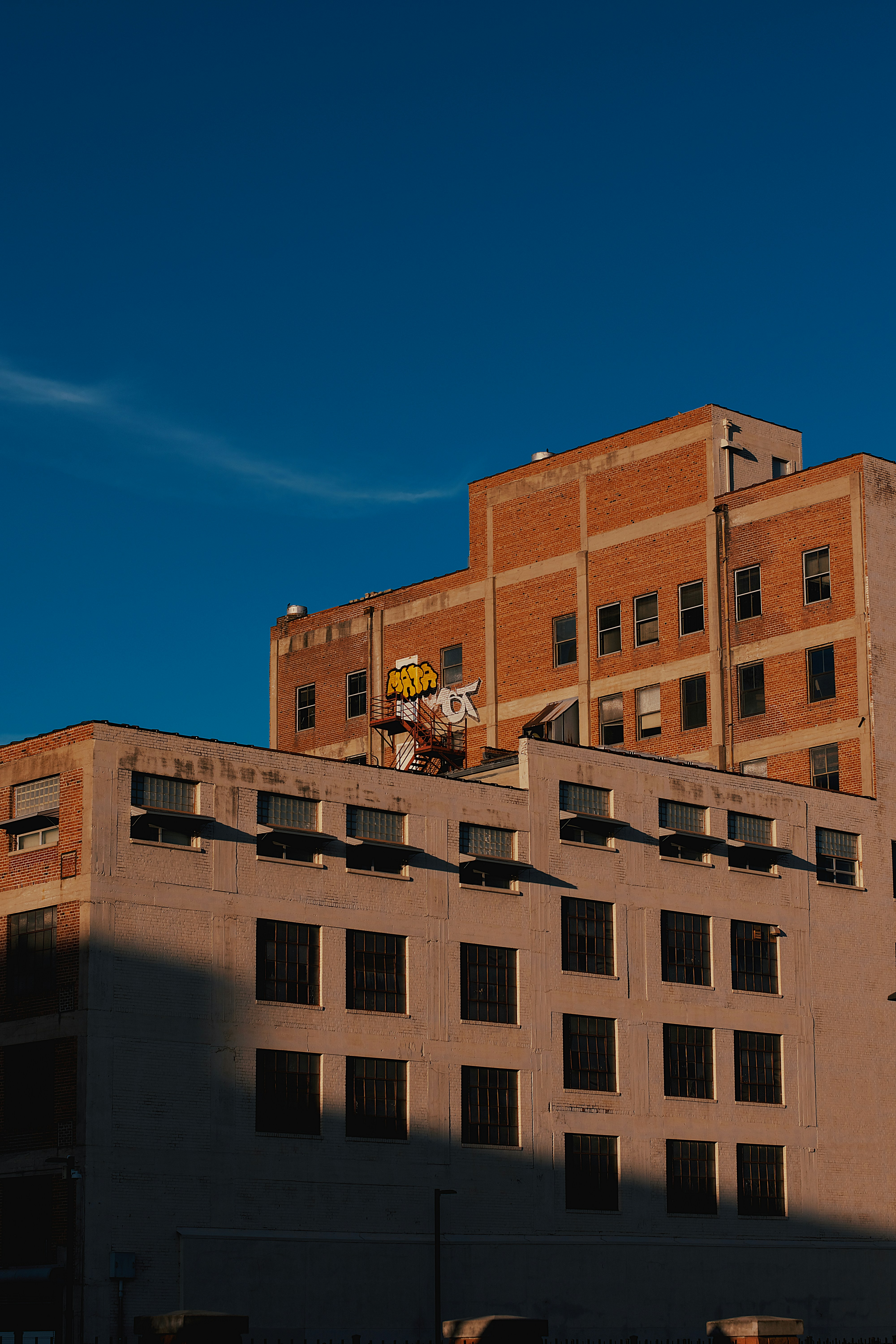 Buildings are bathed in sunlight against a blue sky.