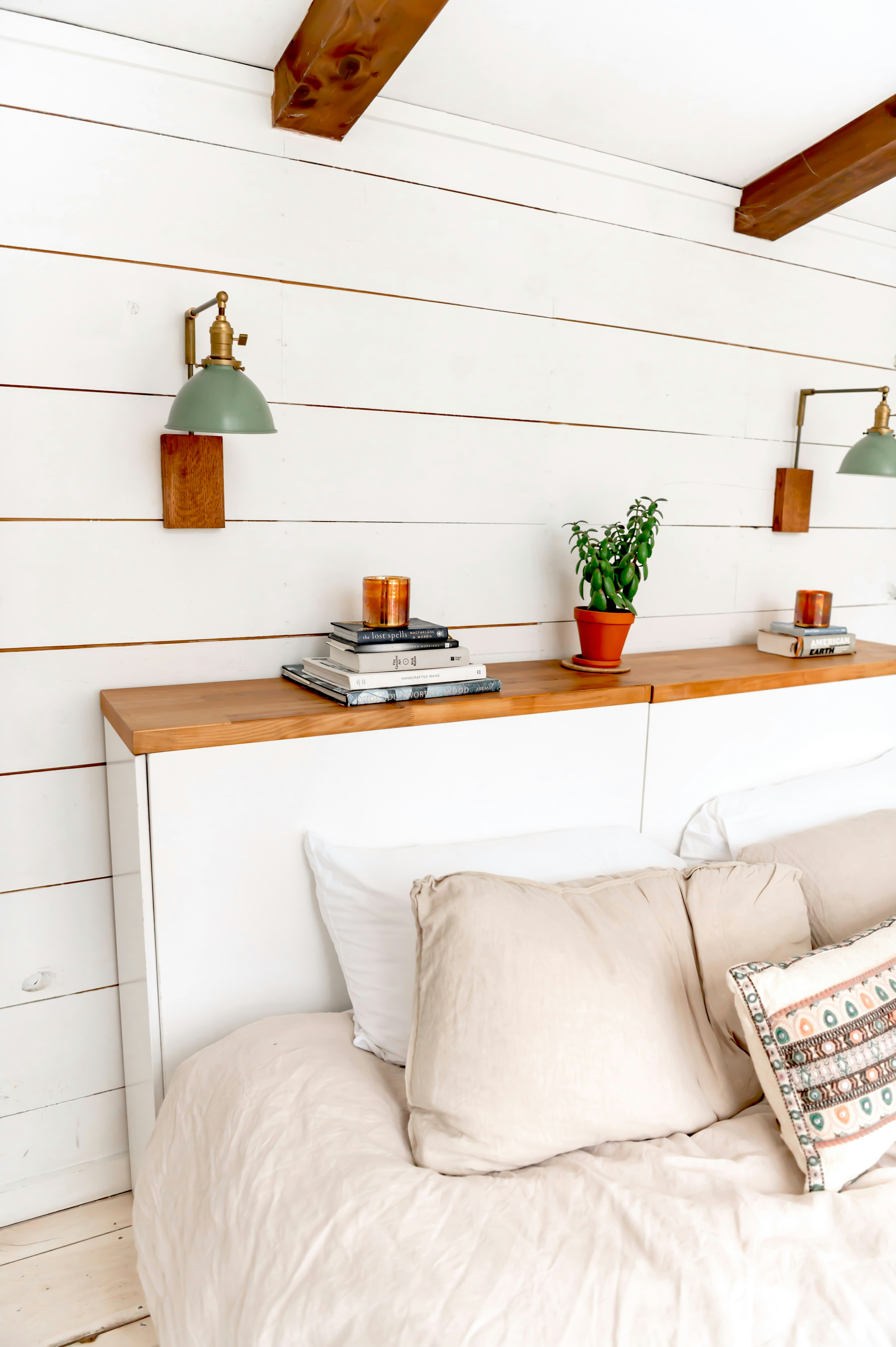 Quarto aconchegante com luminárias de parede e prateleiras de cabeceira.