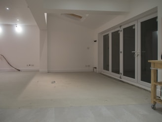 Empty room with white walls and glass doors.