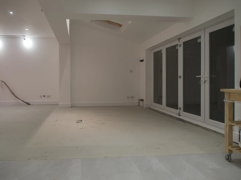 Apartamento en obra gris con paredes sin acabar y ventanales