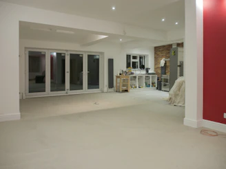 An empty, renovated living room with large doors.
