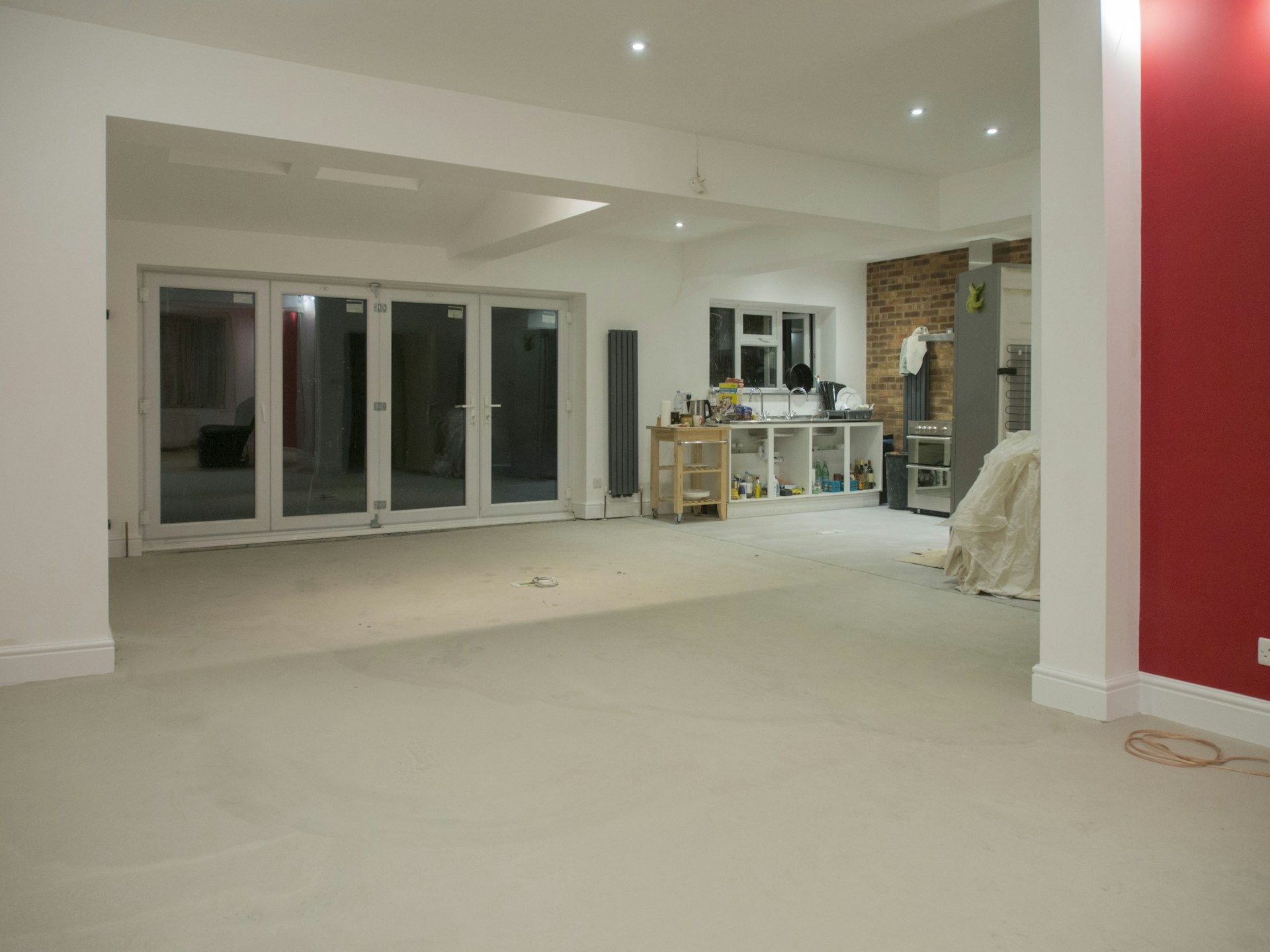 An empty, renovated living room with large doors.