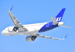 A sas airplane is flying in the sky.
