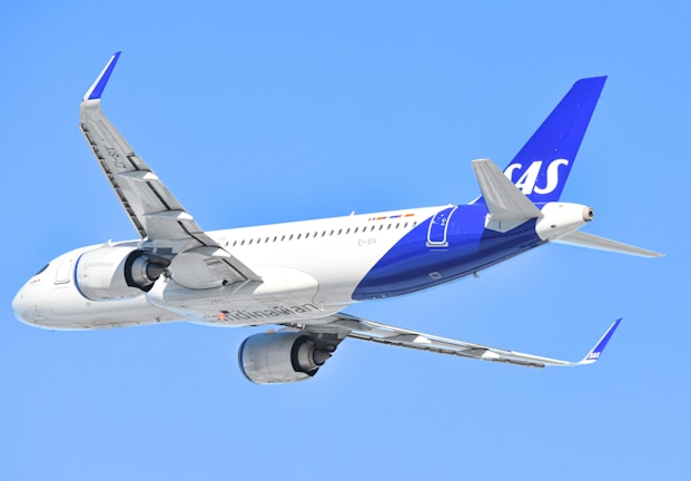 A sas airplane is flying in the sky.