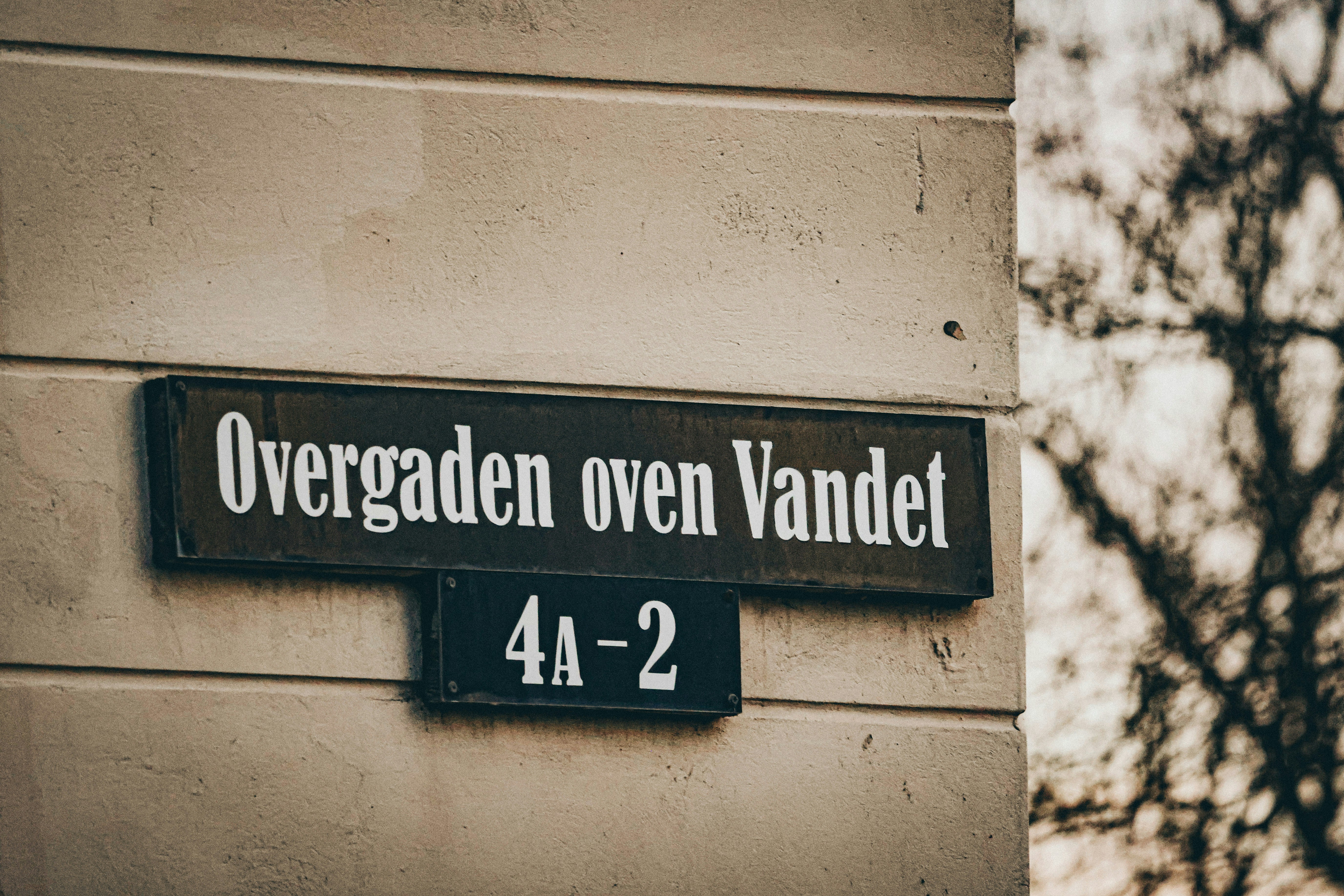 Ein Straßenschild an einer Gebäudefassade ist zu sehen.