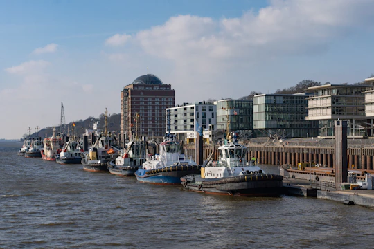Boats are docked near buildings on a waterfront.