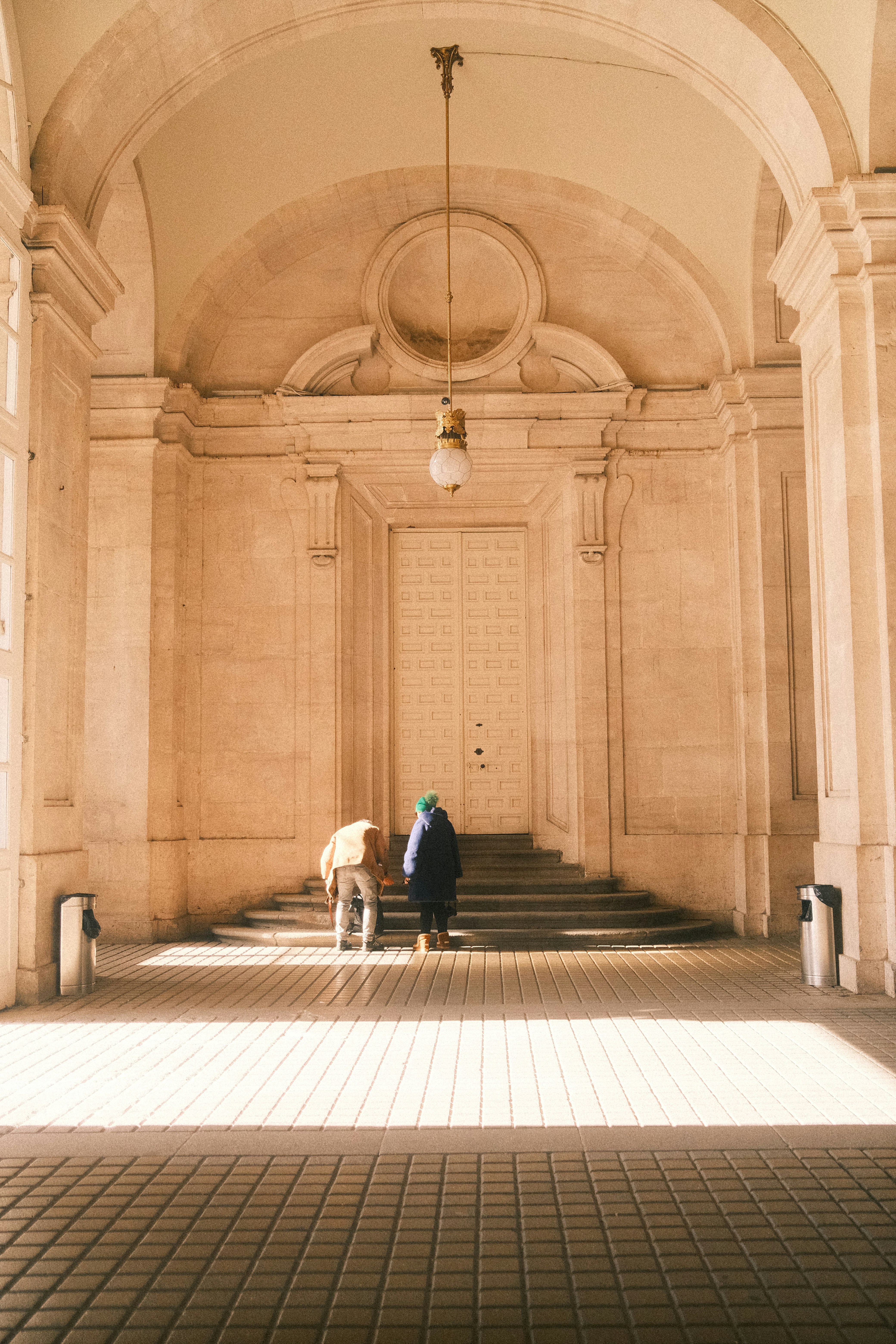 Two people approach a large, ornate door.