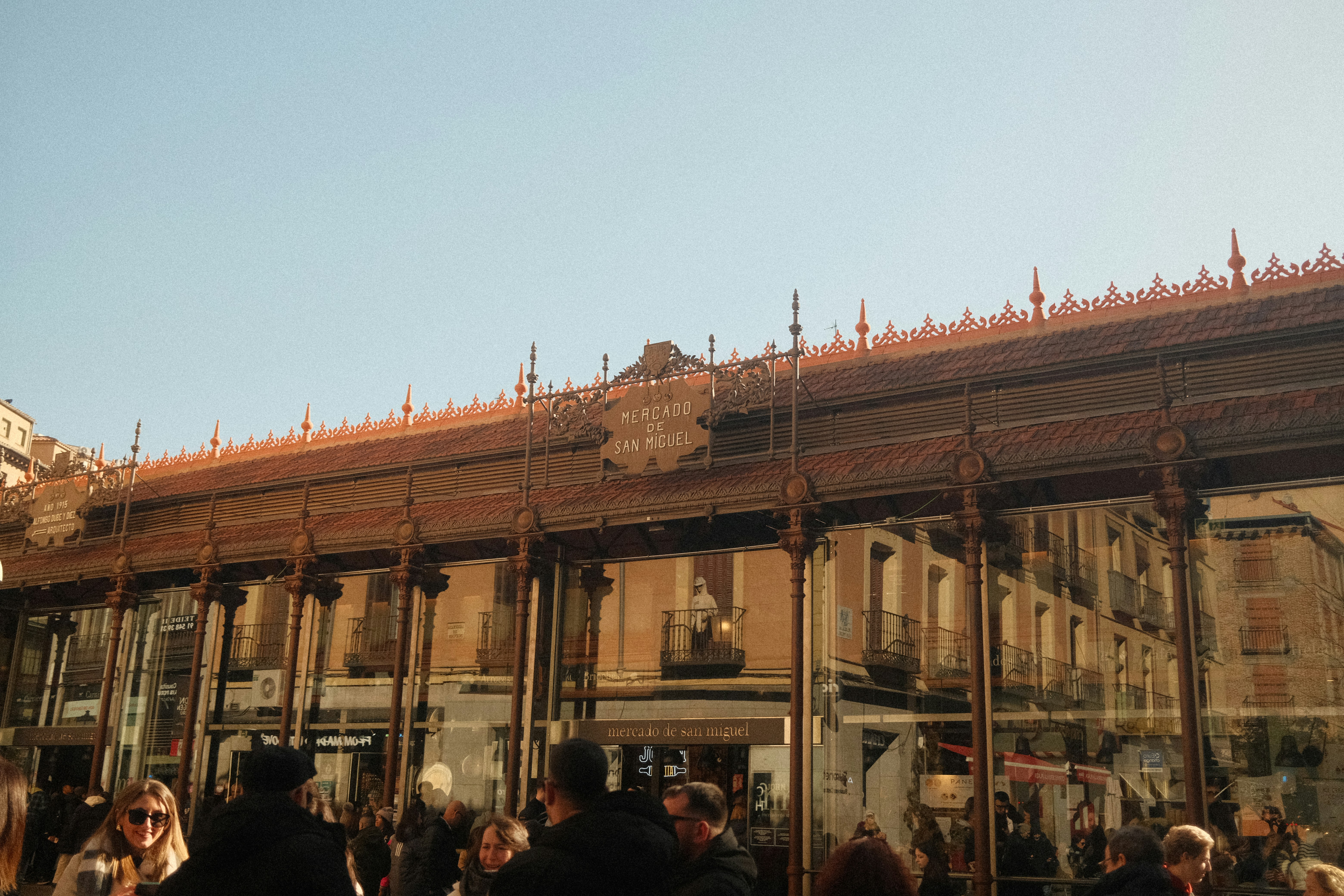 People walk near a market building.