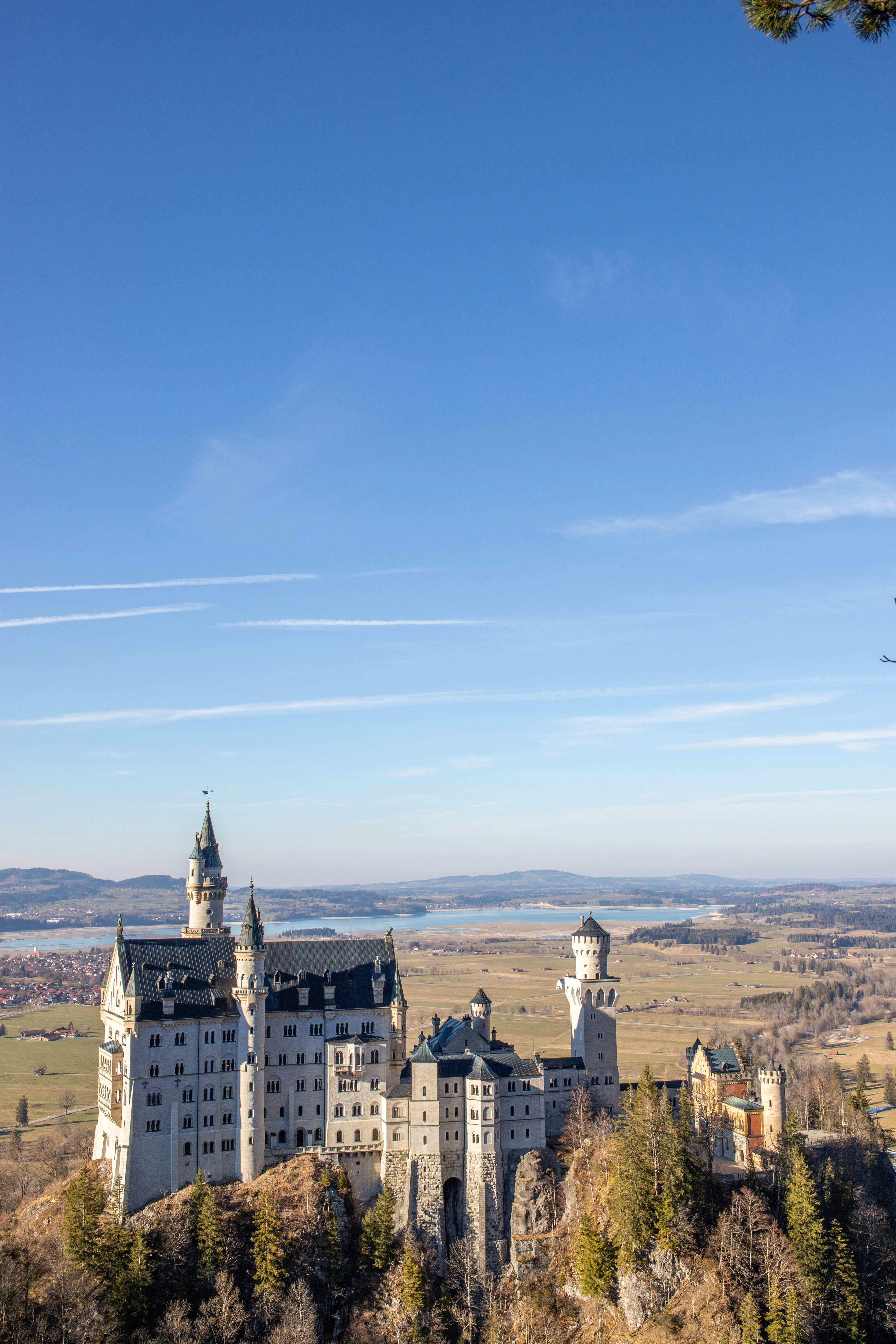 Neuschwanstein castle sits beneath a bright blue sky.