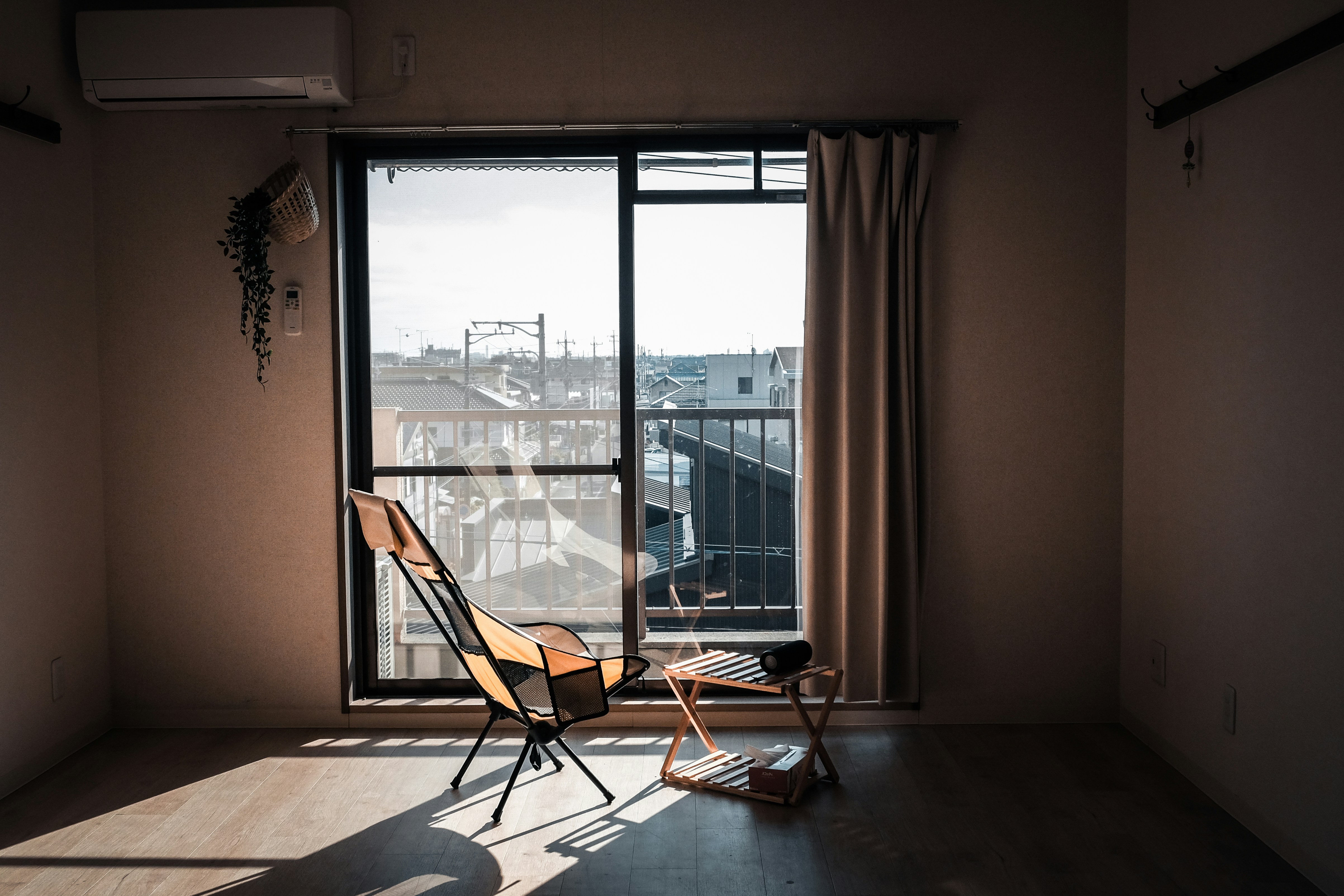 Sunlight streams into a simple room with chairs.