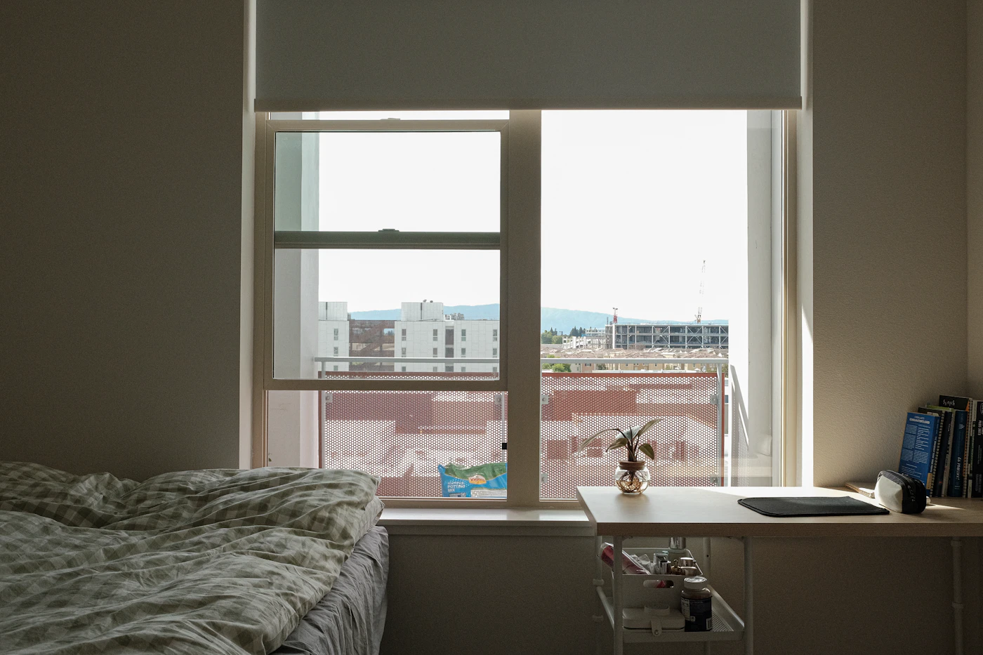 Helles Schlafzimmer mit großem Fenster als Symbol für Lüften und rauchfreie Wohnräume