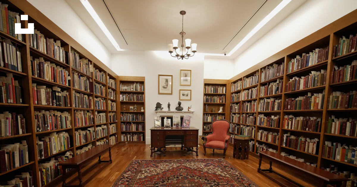 A library filled with books, a desk, and rug. photo – Free Art Image on ...