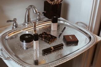 Makeup products arranged on a silver tray.