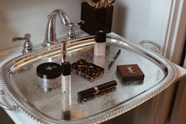 Makeup products arranged on a silver tray.
