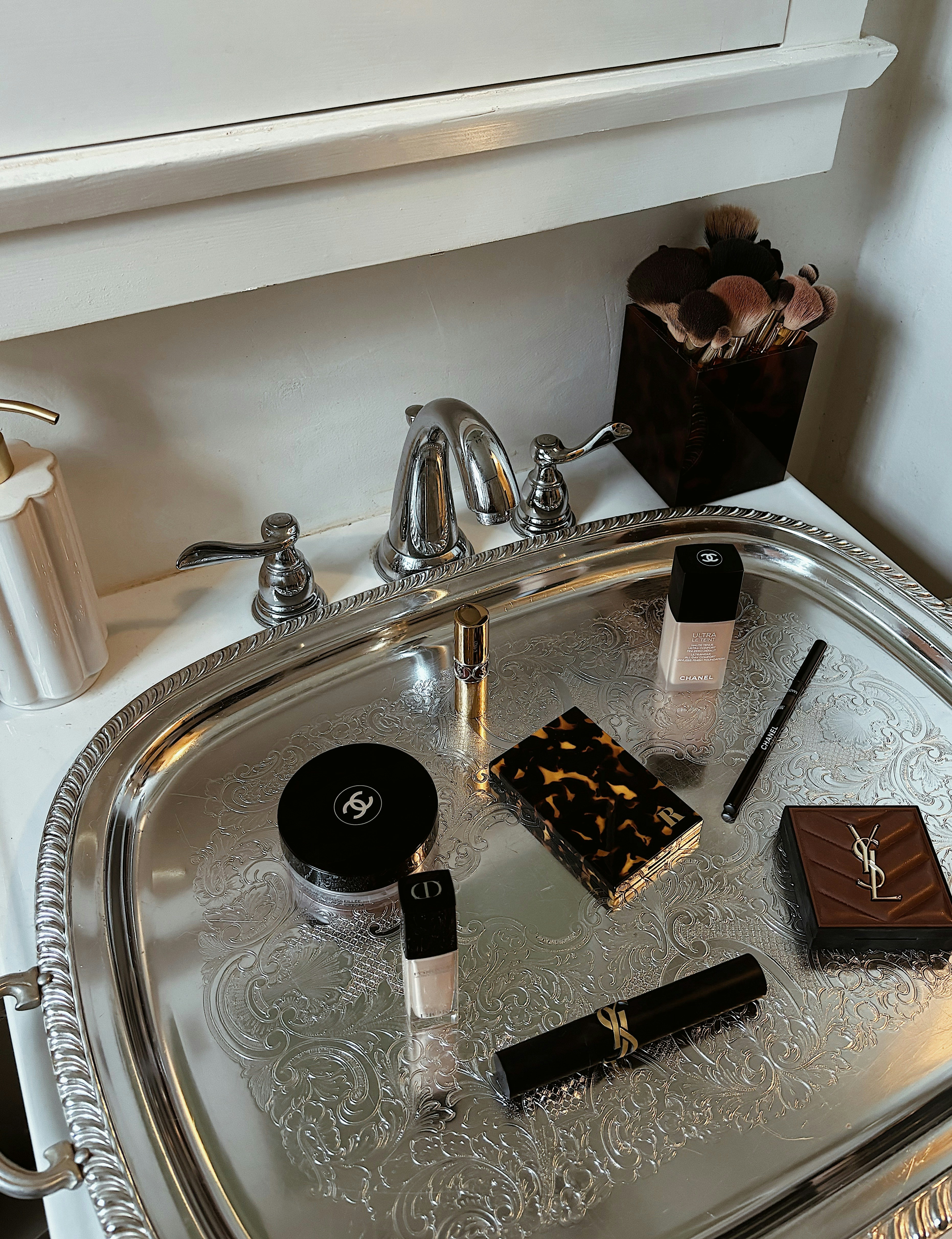 Makeup products displayed on a silver tray.