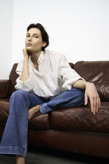 Woman relaxes on a red leather couch.