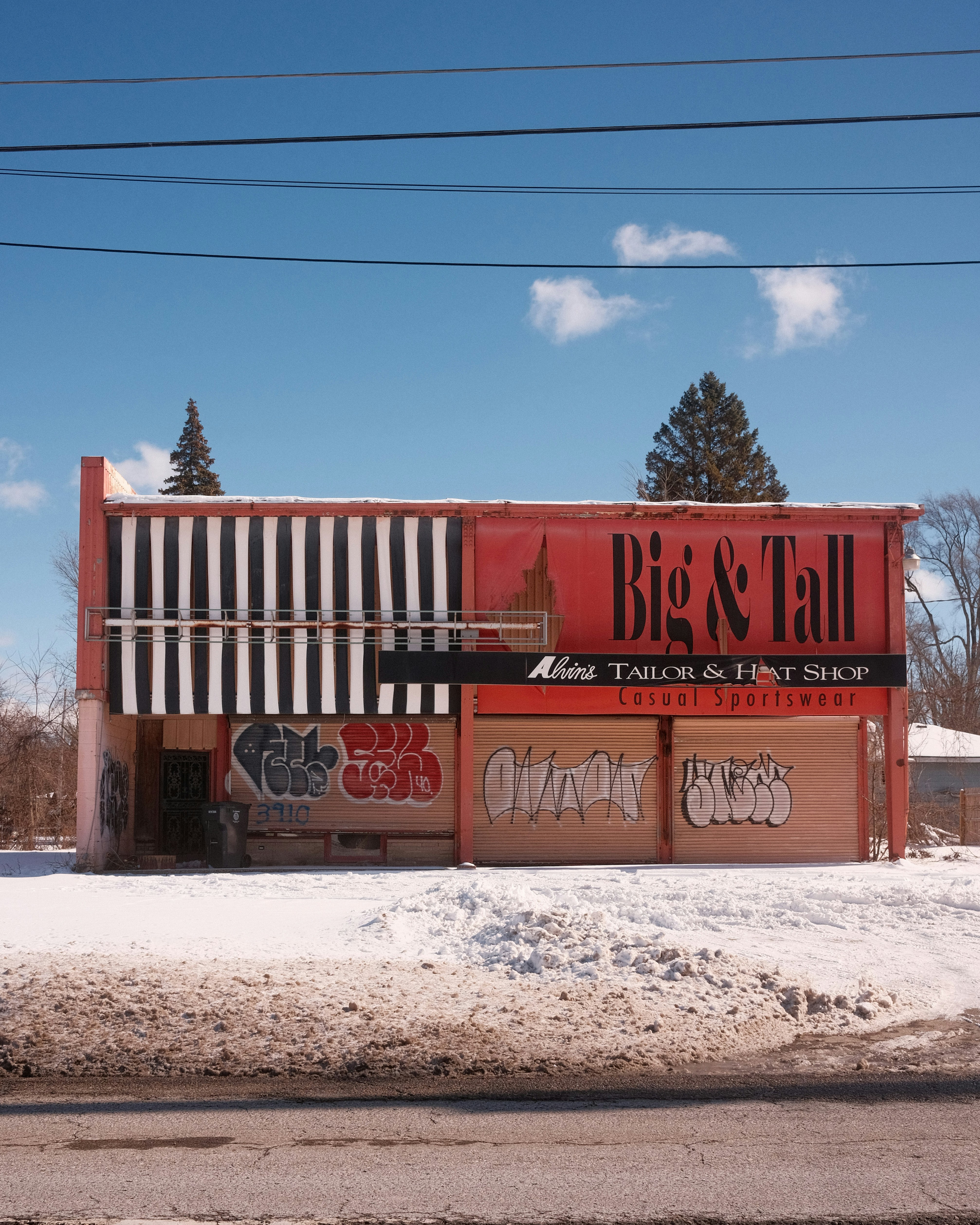 A red building covered in graffiti sits in snow.