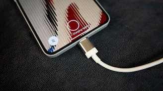 A phone is charging with its cable.