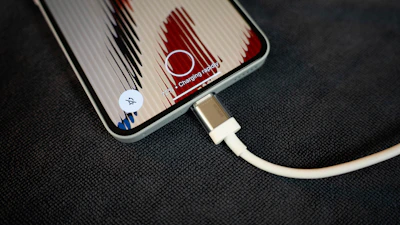 A phone is charging with its cable.