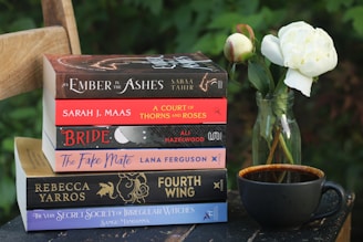 Books, flowers, and a cup of tea create a cozy scene.