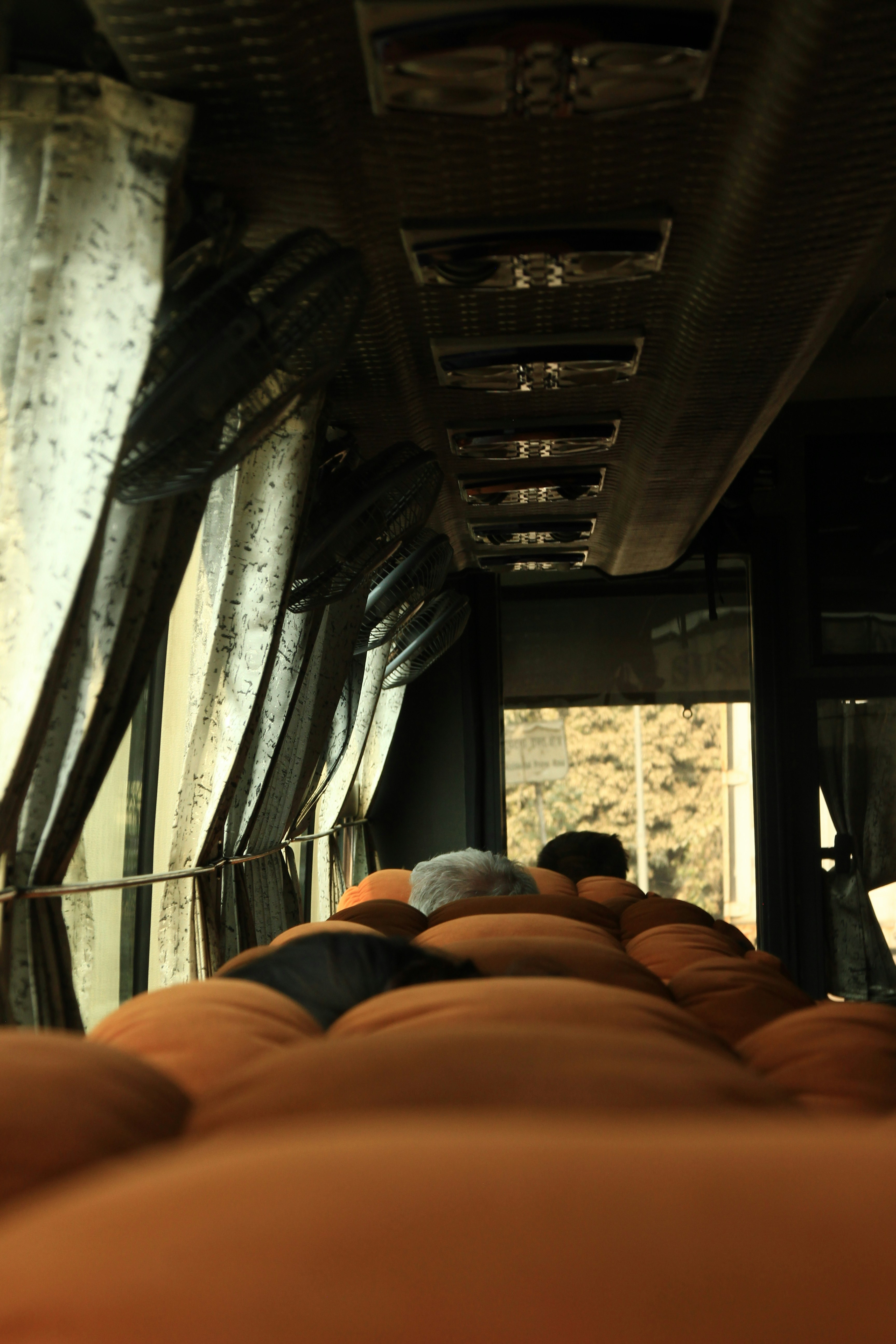 The interior of a public transit bus, looking down the aisle — the visual layout most overnight buses share