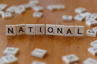 Scrabble tiles spell the word: national.