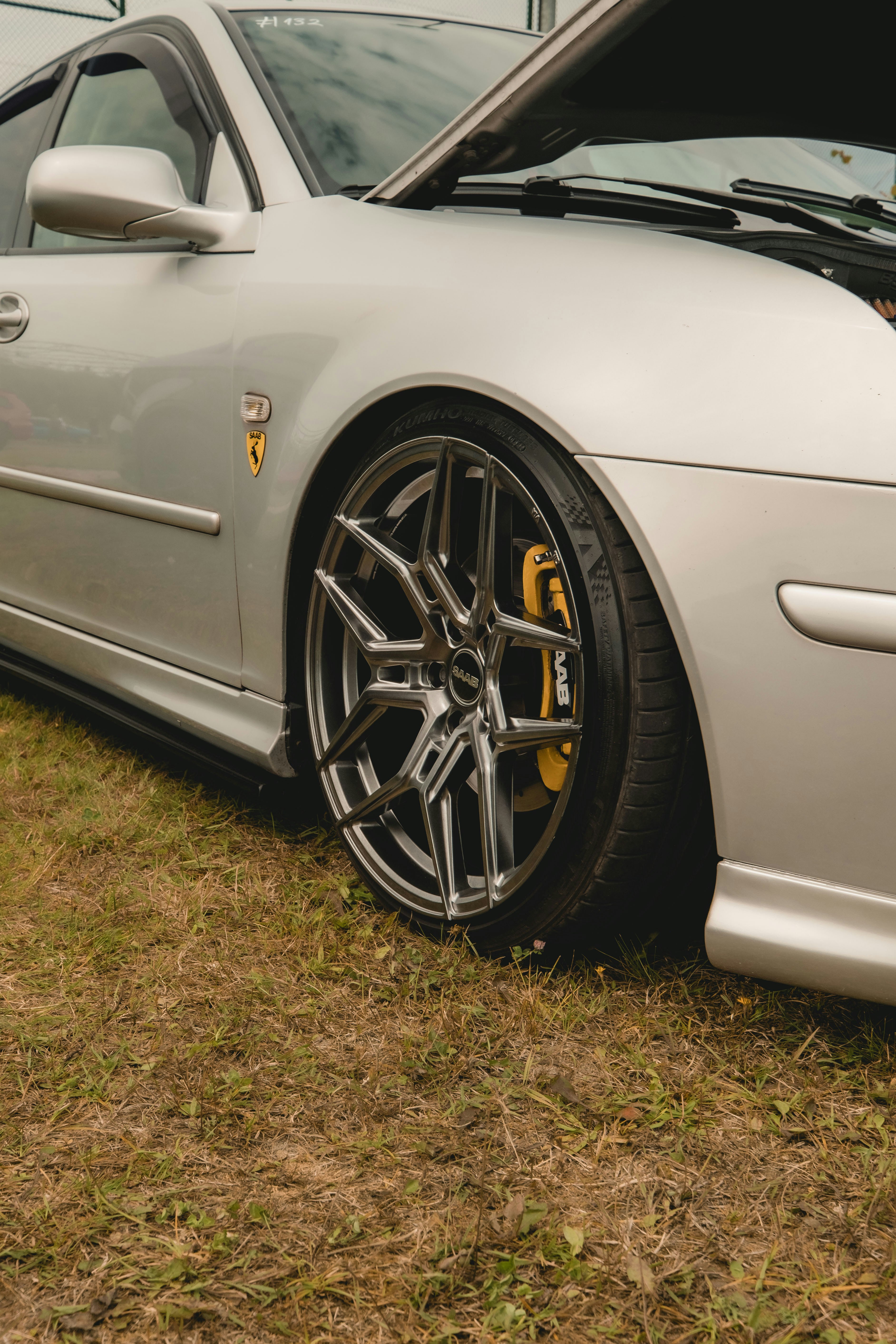 A silver car with custom wheels is shown.