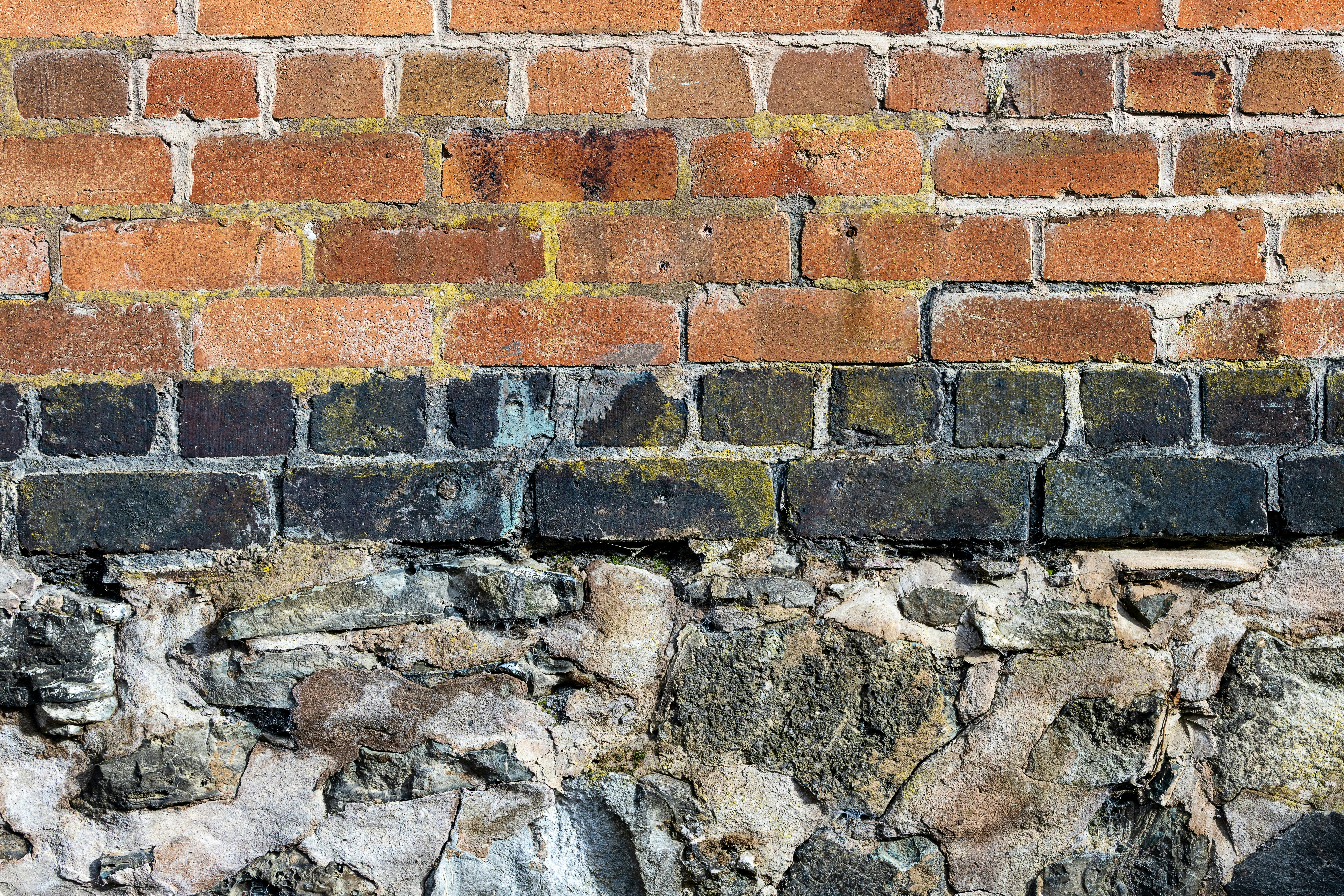 Brick wall with stone foundation is shown.