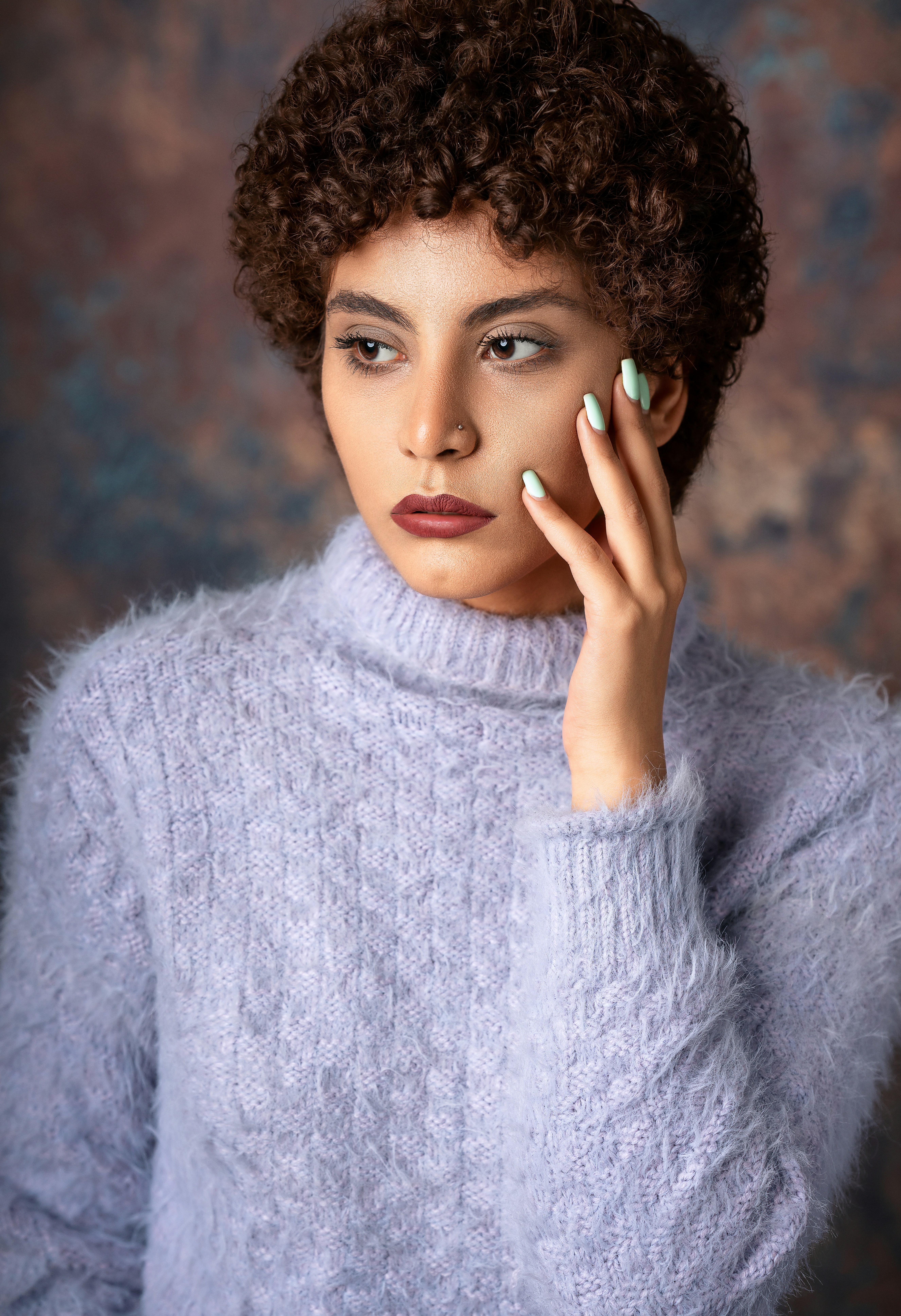 A woman in a sweater poses for a portrait.