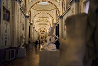 Museum hallway with statues and a vaulted ceiling.