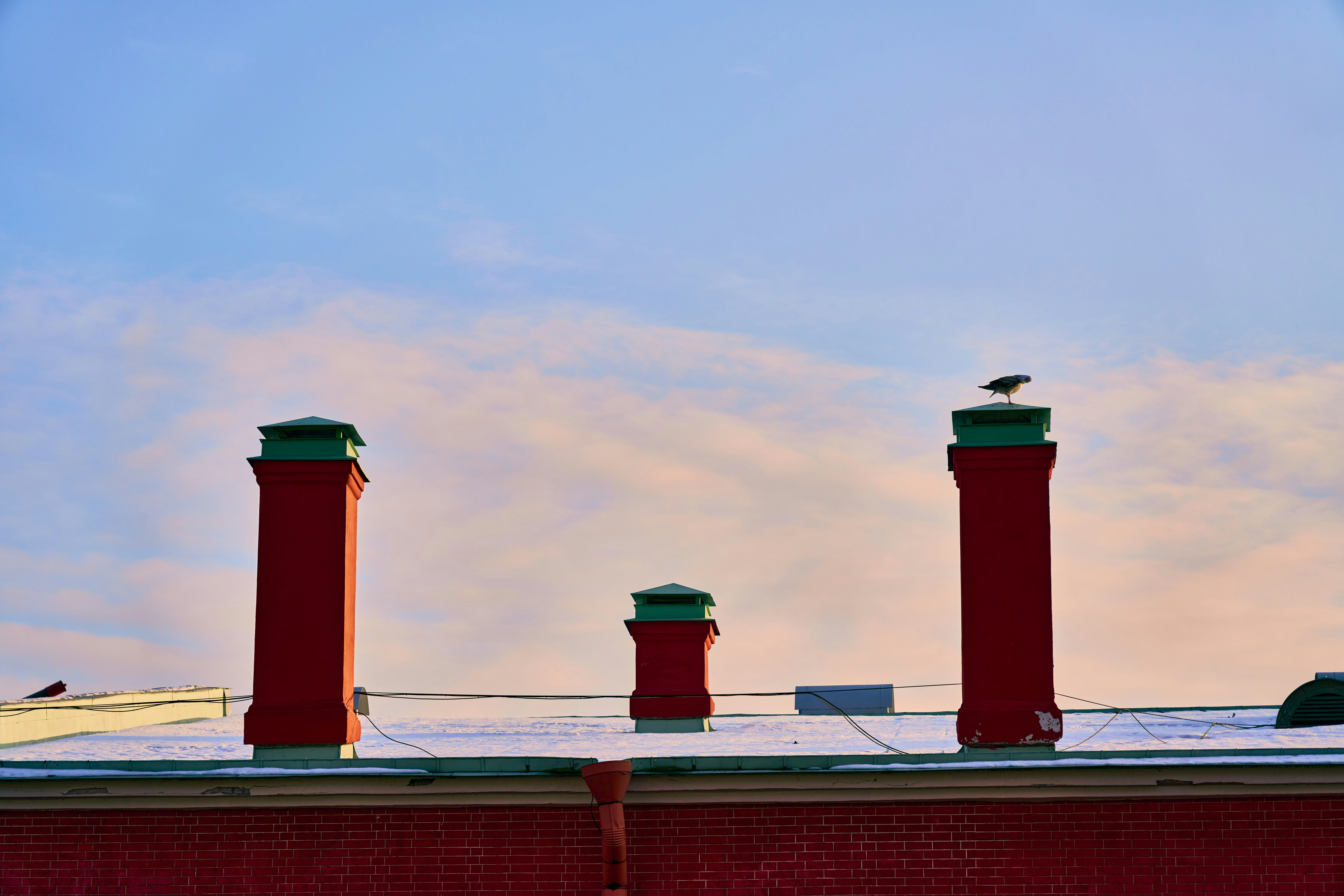 Chimneys stand tall under a colorful sky.