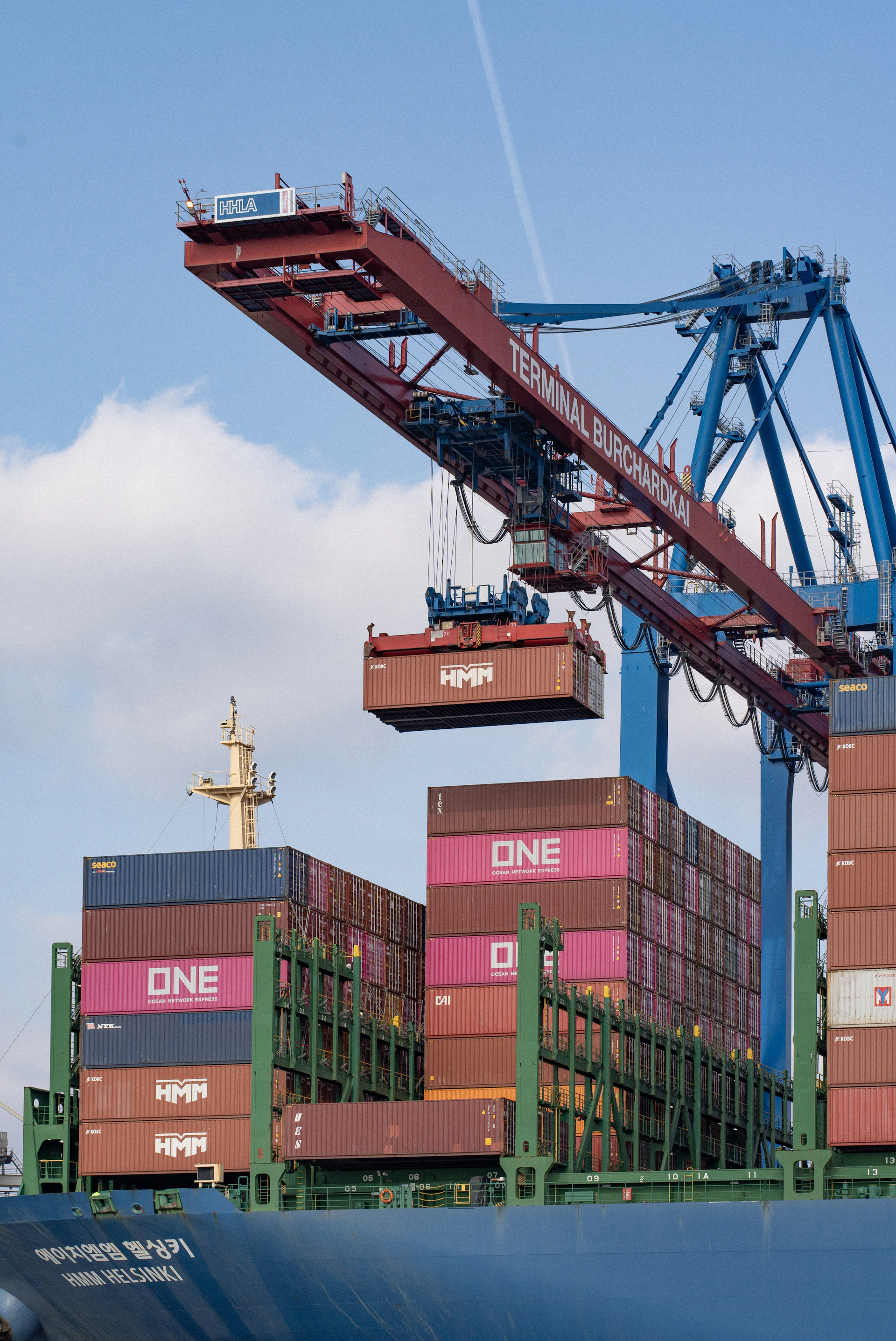 Crane loads cargo containers onto a ship.
