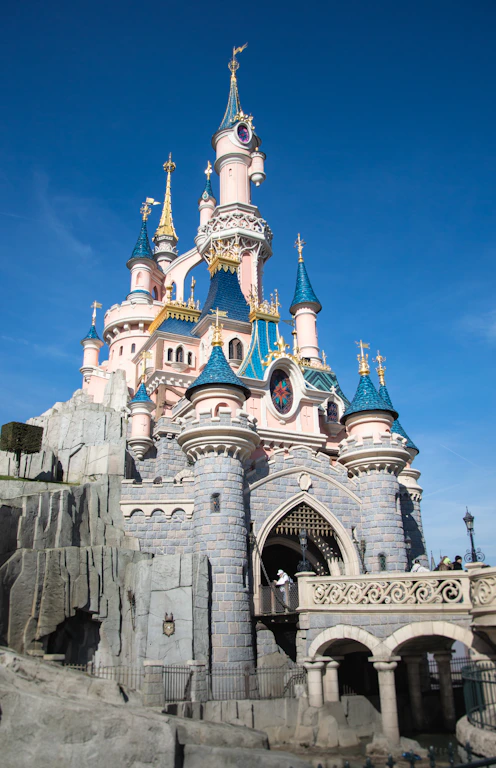 The sleeping beauty castle stands tall under a clear sky.