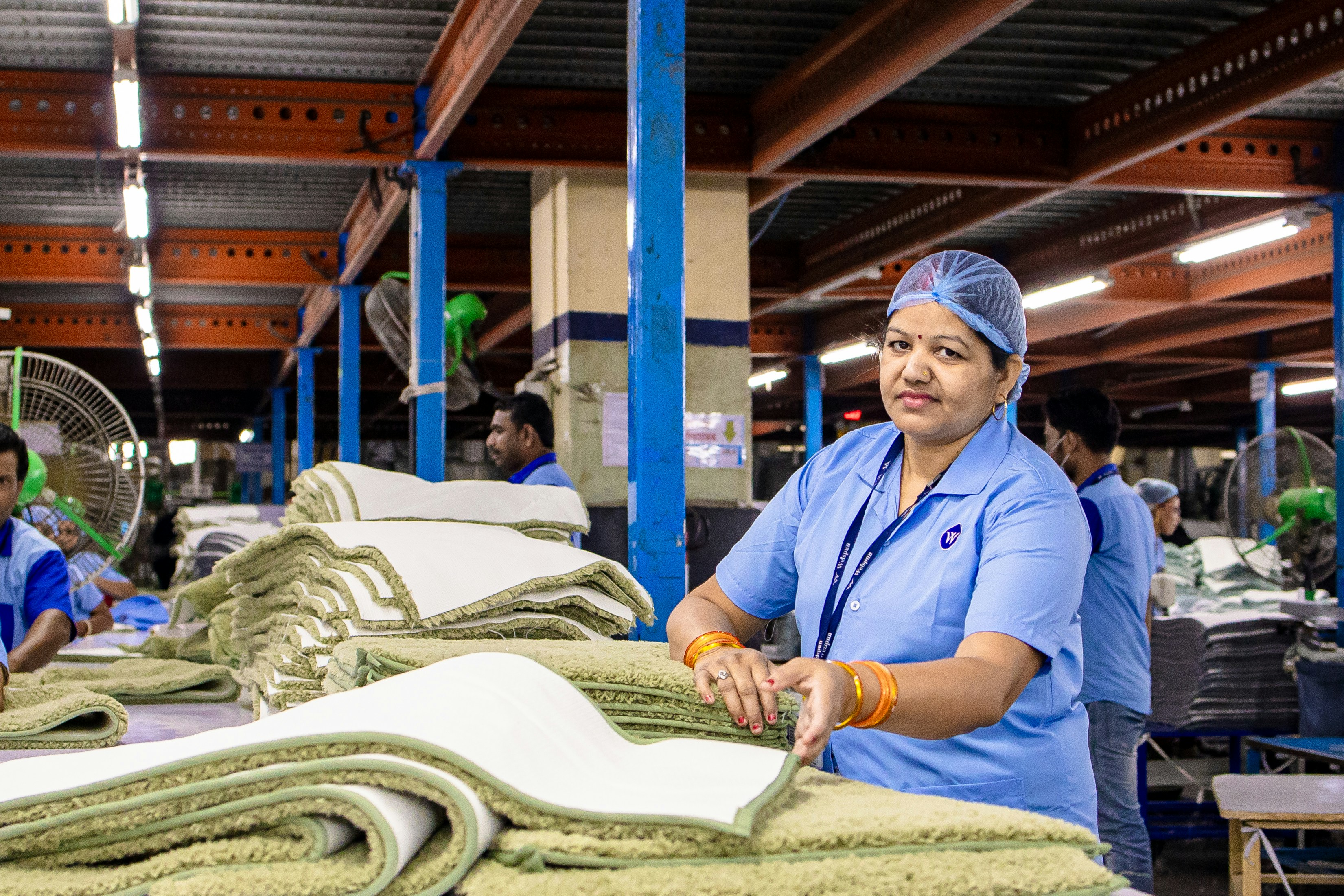 Un ouvrier d’usine sourit en travaillant avec des textiles.