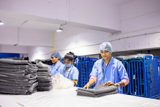 Employees are folding clean laundry in a factory.