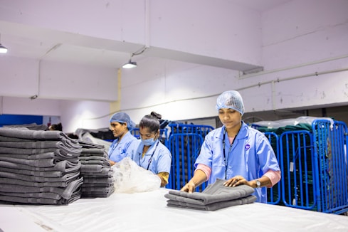 Employees are folding clean laundry in a factory.