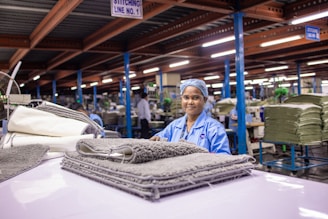 Woman smiles at camera in a factory.
