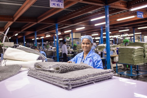 Woman smiles at camera in a factory.
