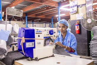 A woman sews in a factory.