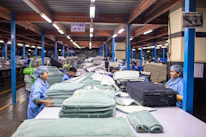 Textile workers are sorting fabric in a factory.