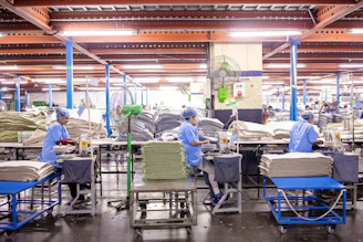 Workers are in an industrial textile manufacturing facility.